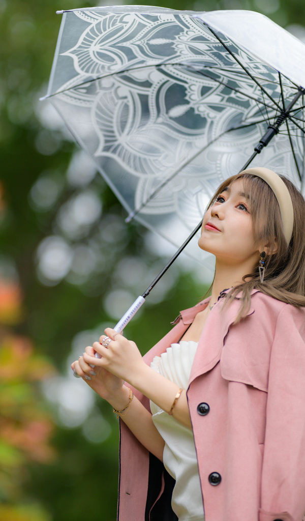 Девушка азиатка в пальто под прозрачным зонтом