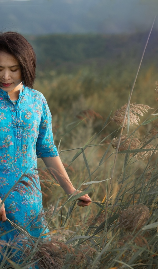 Девушка азиатка в платье на поле с колосьями