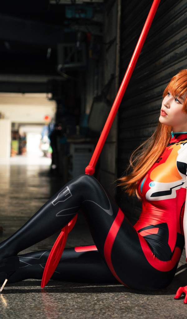 Девушка азиатка в костюме сидит у стены