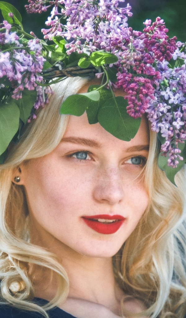 Красивая голубоглазая девушка с венком из сирени на голове