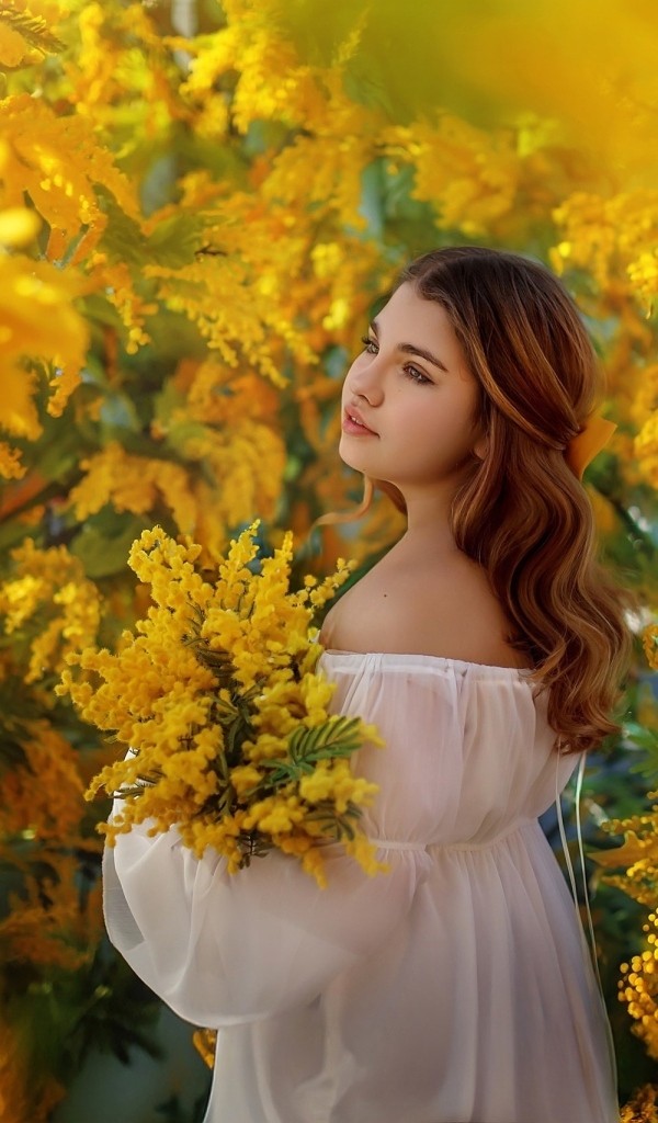 Красивая девушка в зарослях мимозы
