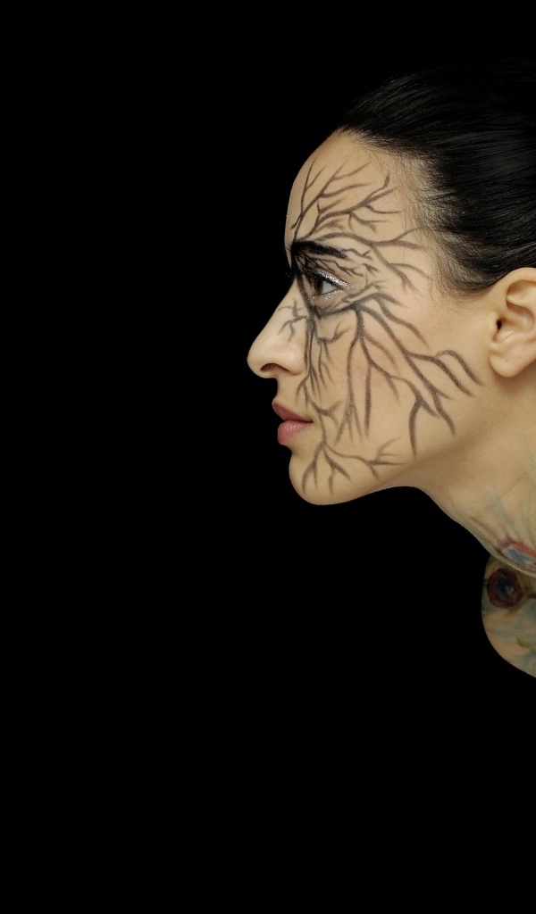 Красивая девушка с рисунком на теле на черном фоне