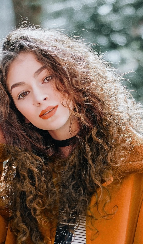 Красивая девушка с кудрявыми волосами и карими глазами