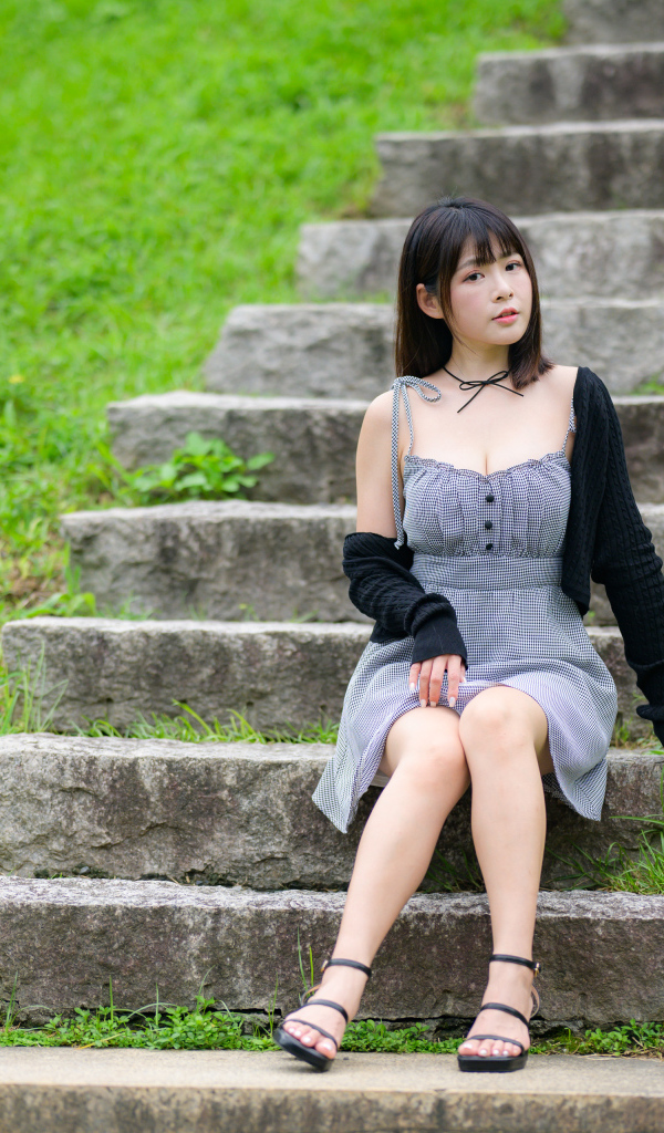 Красивая молодая девушка азиатка сидит на ступеньках