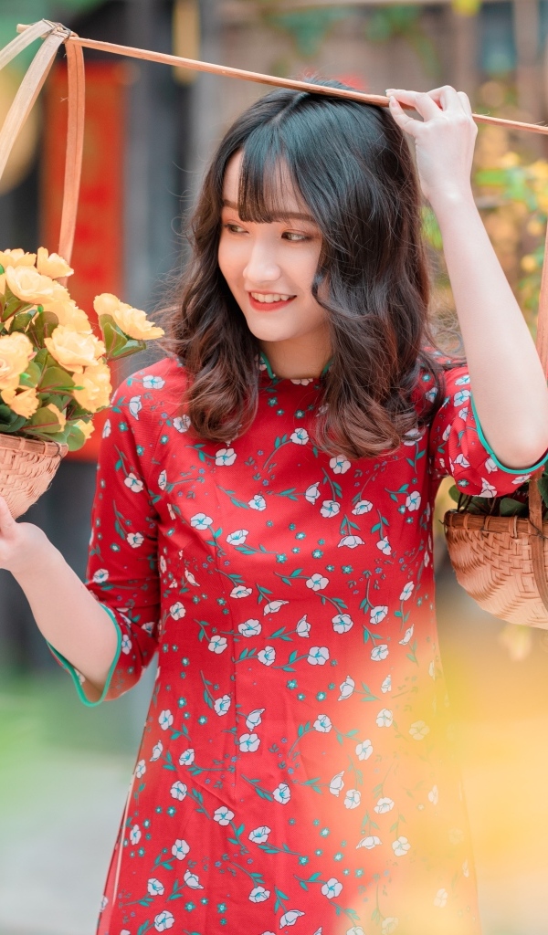 Милая девушка азиатка с цветами в красном платье