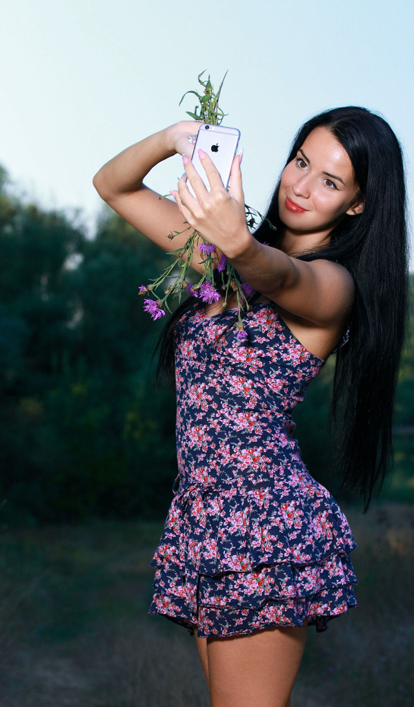 Милая брюнетка в коротком платье делает фото