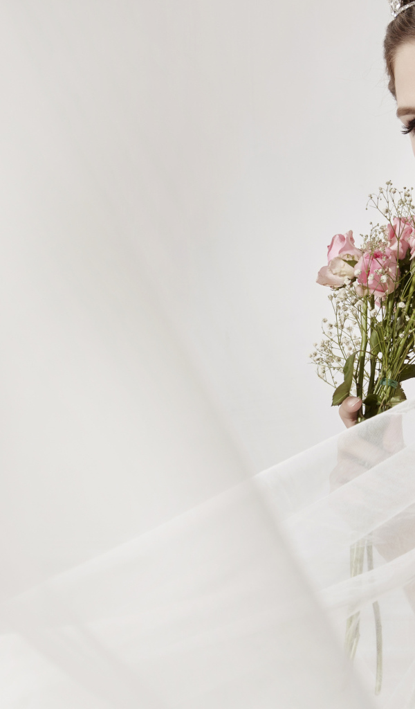 Милая девушка в костюме невесты с букетом цветов