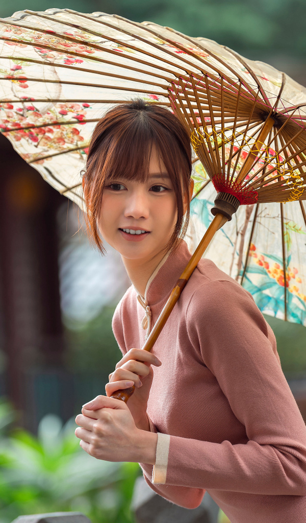 Милая улыбающаяся азиатка с зонтом