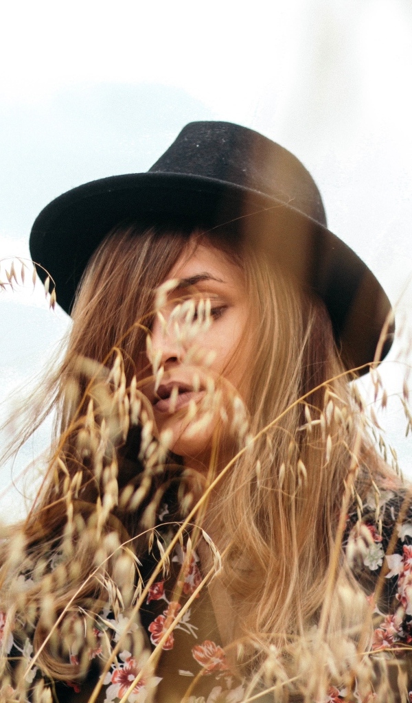 Девушка в черной шляпе в траве