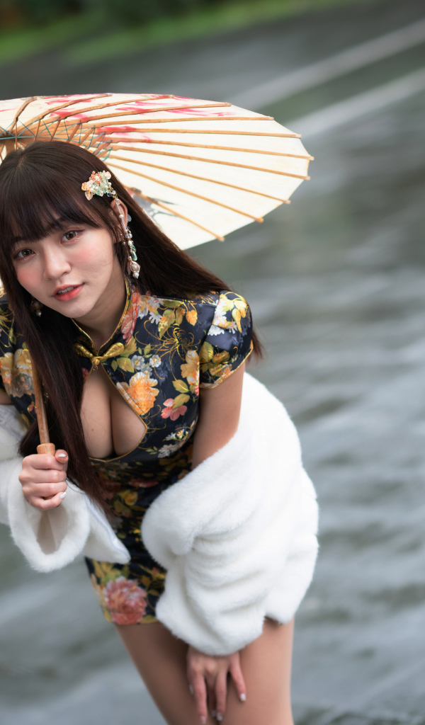 Настоящая азиатка стоит под зонтом