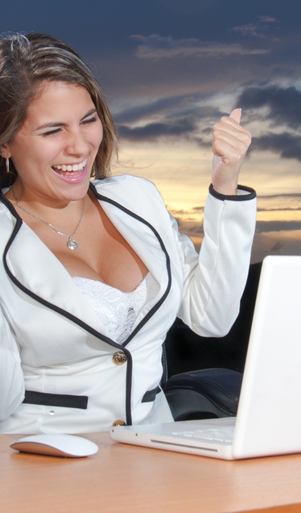 Довольная женщина с карточкой за столом с ноутбуком