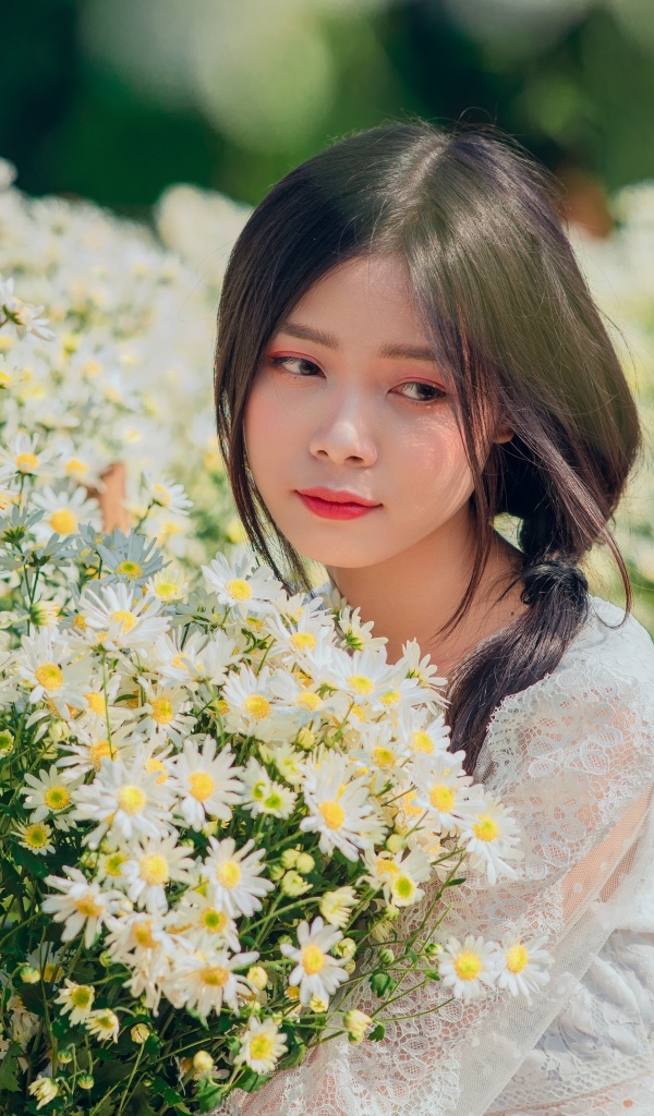 Нежная девушка азиатка с цветами ромашки