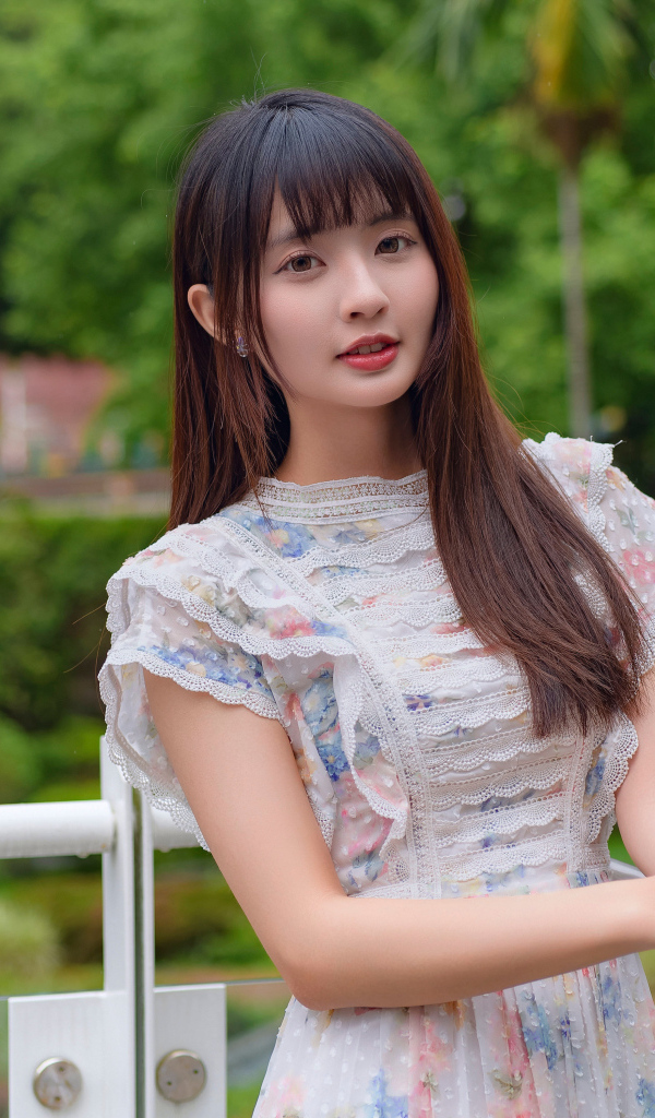 Нежный взгляд молодой длинноволосой азиатки в платье