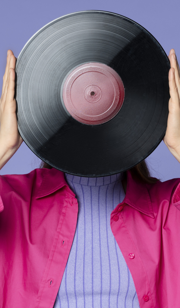 Девушка закрыла лицо пластинкой 