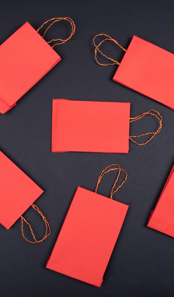 Красные пакетики для подарков на черном столе