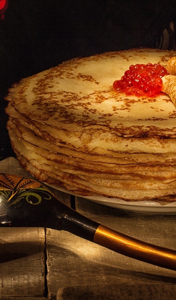 Тонкие блинчики с икрой и деревянной ложкой на Масленицу