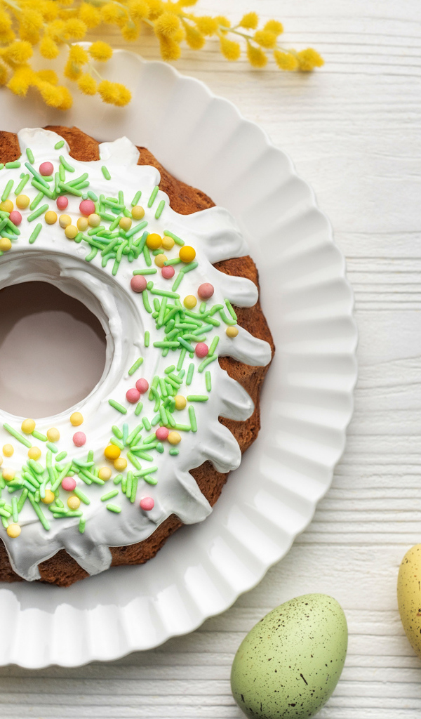 Красивый пасхальный кулич с веткой мимозы и яйцами