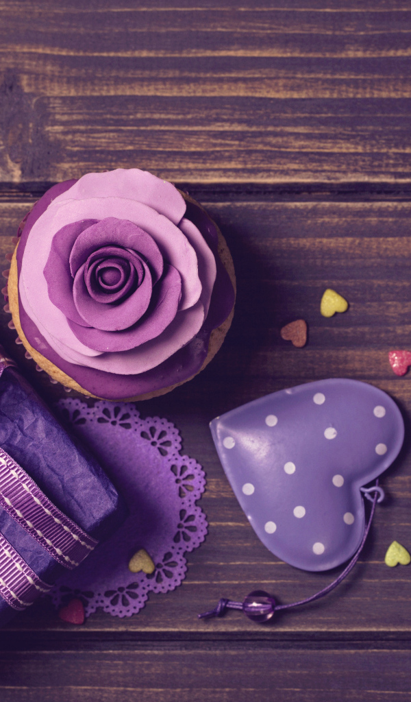 Подарок рядом с кексом, сердечком и открыткой