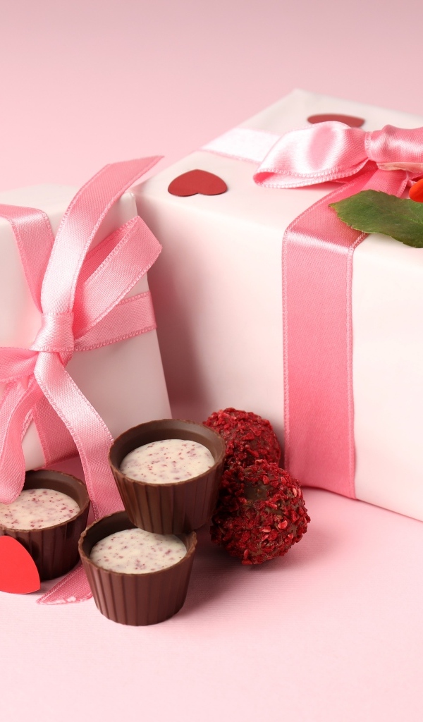 Два подарка с конфетами на розовом фоне на День Святого Валентина