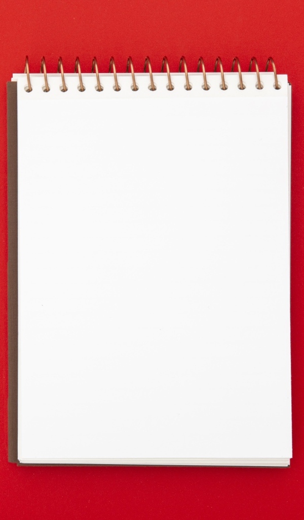 Блокнот и фломастеры на красном фоне