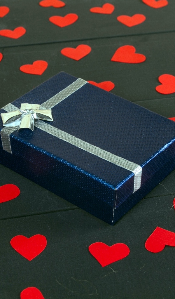 Черная коробка с красными сердечками на столе