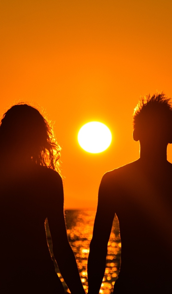 Влюбленная пара на фоне заката у моря