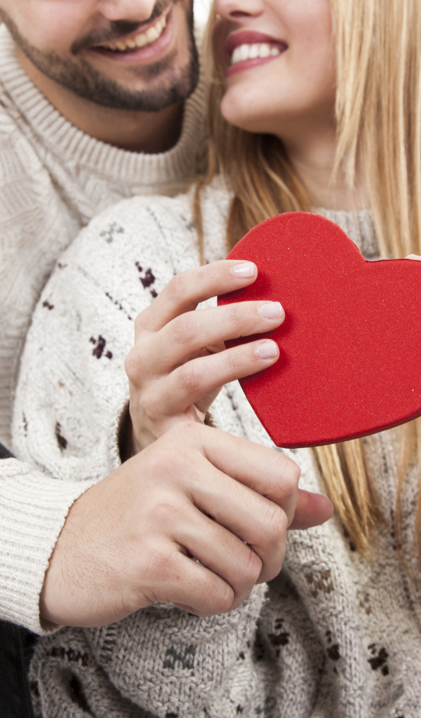 Влюбленная пара с красным сердцем в руках
