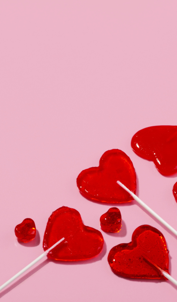 Леденцы в форме сердца на розовом фоне
