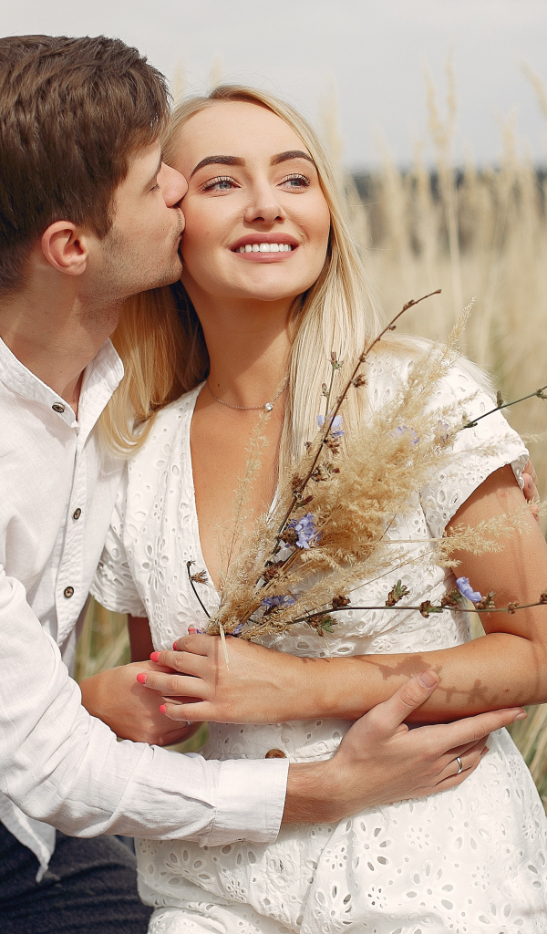 Поцелуй красивой пары на поле