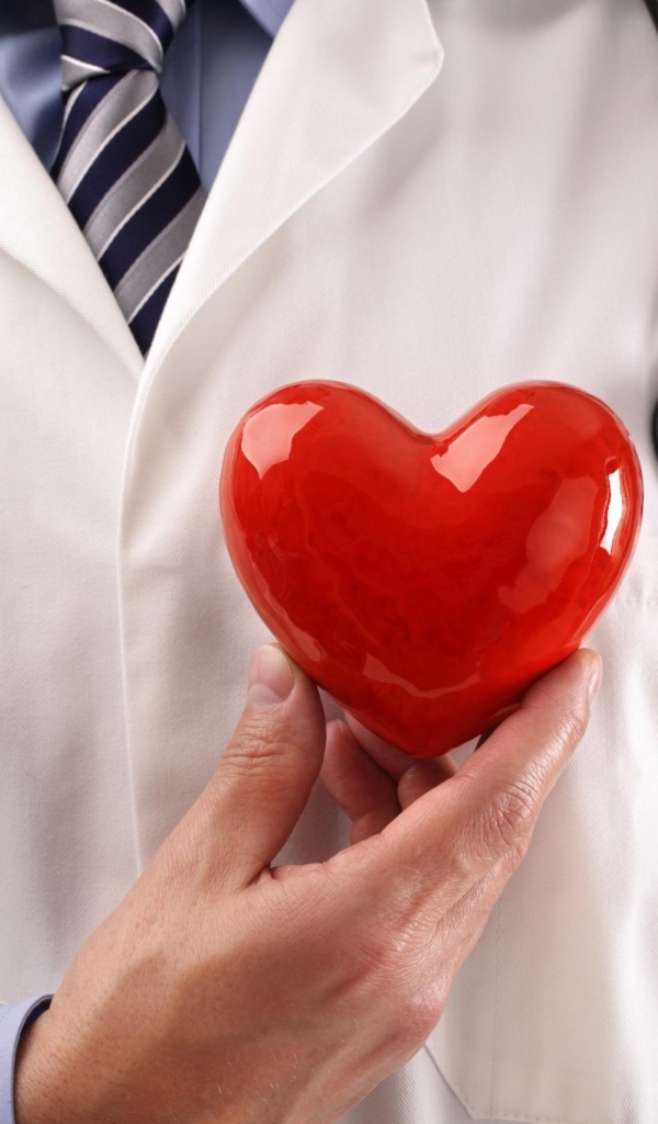 Красное сердце в руках доктора в белом халате