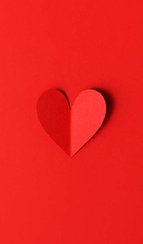 Маленькое бумажное сердце на красном фоне