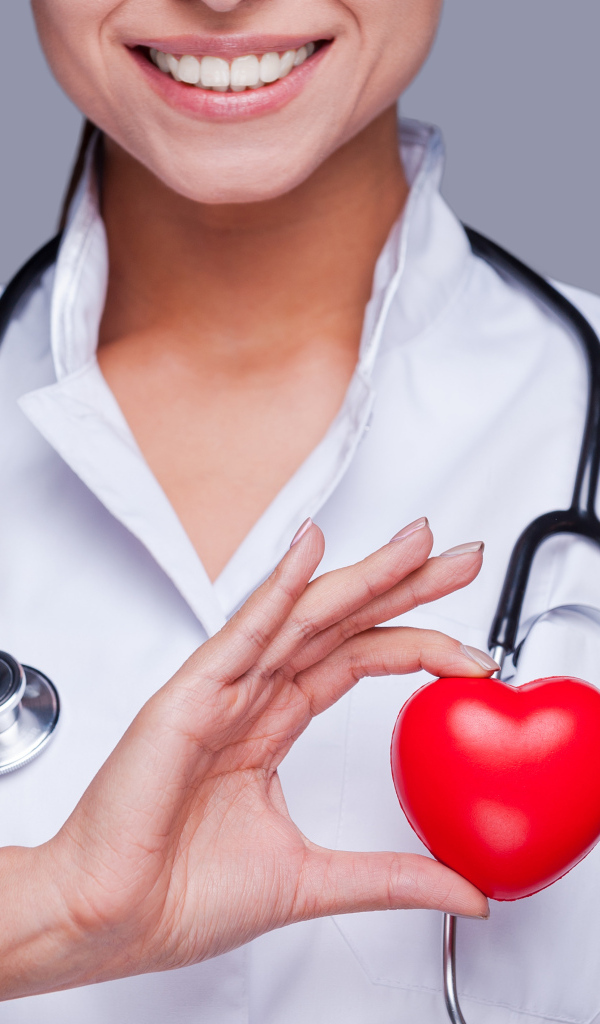 Улыбающаяся женщина врач с красным сердцем