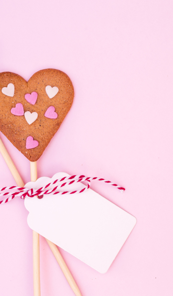 Два сердечка на палочке на розовом фоне