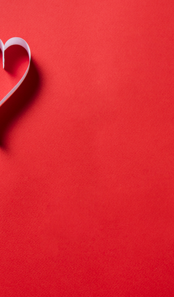 Два белых бумажных сердца на красном фоне