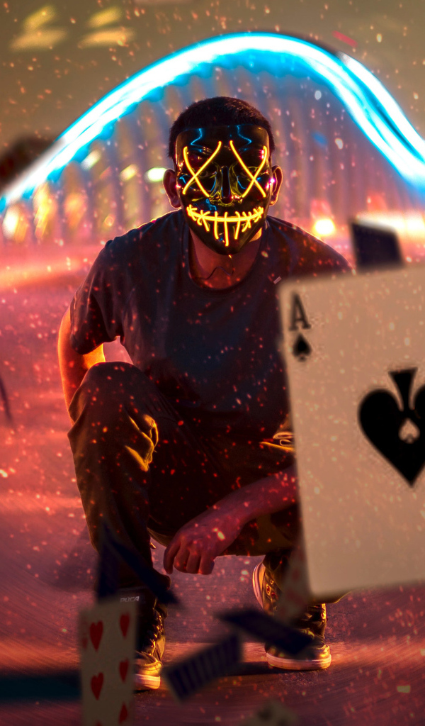 Мужчина в маске бросает карты