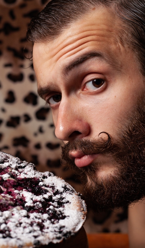 Мужчина с бородой держит сладкий пирог 