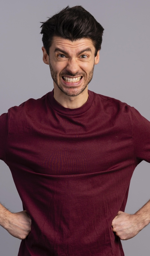 Злой мужчина на сером фоне