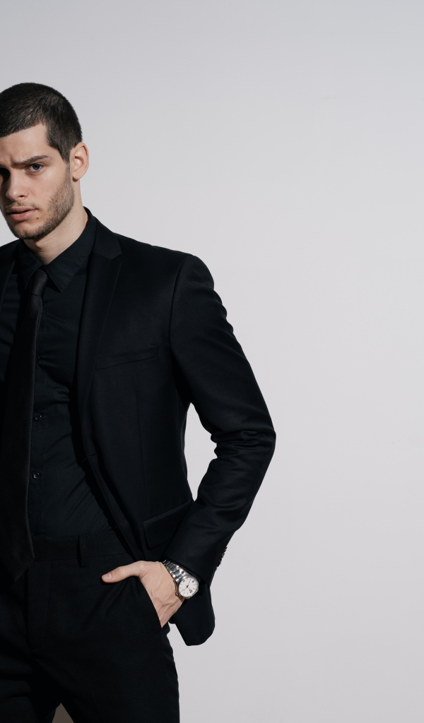 Красивый деловой мужчина стоит у серой стены