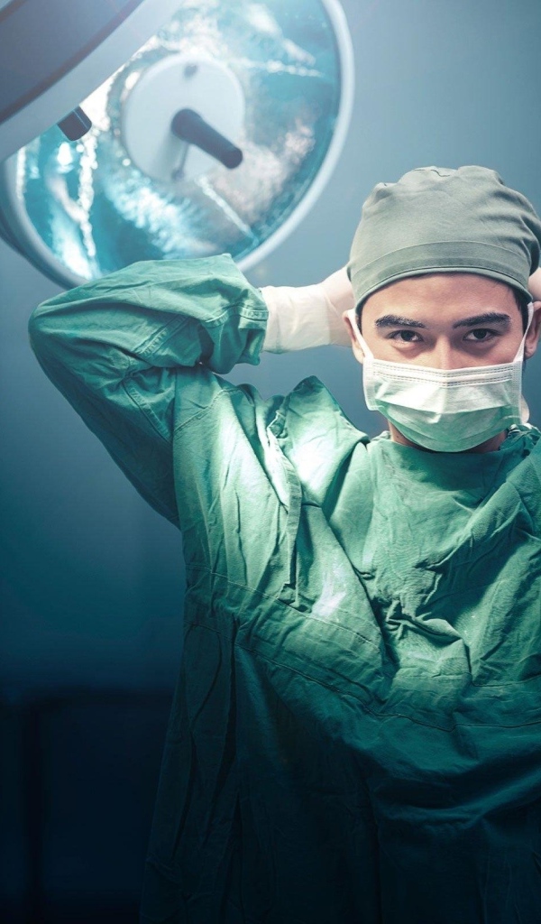 Мужчина врач в костюме в операционной