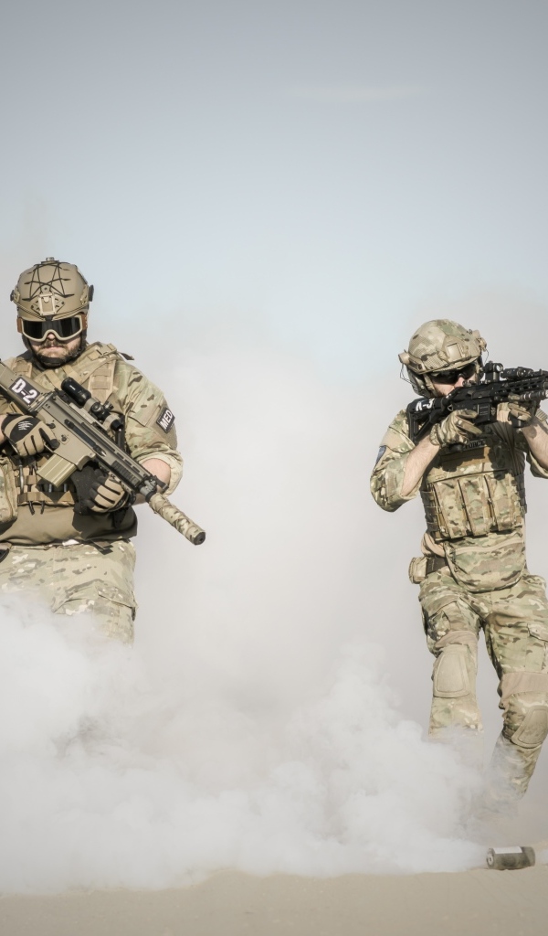 Мужчины солдаты с оружием в дыму