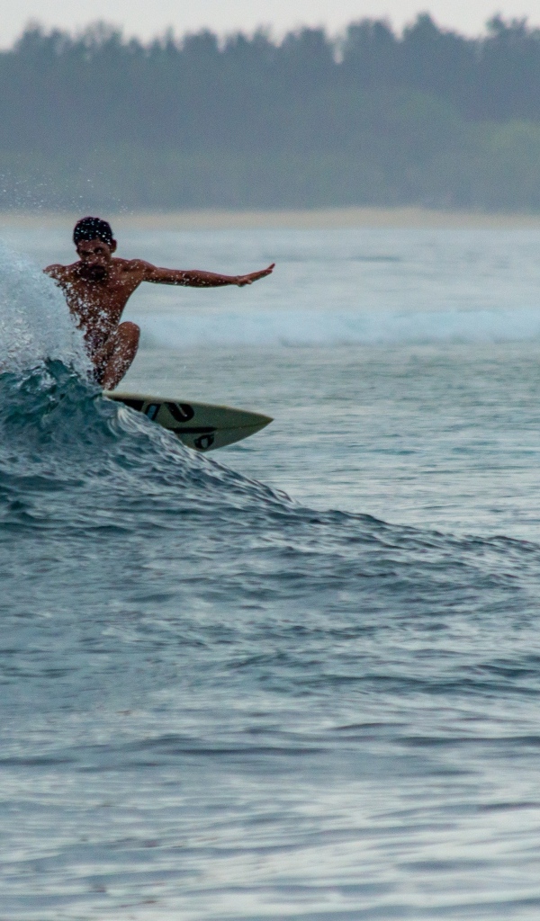 Мужчина серфингист ловит волну