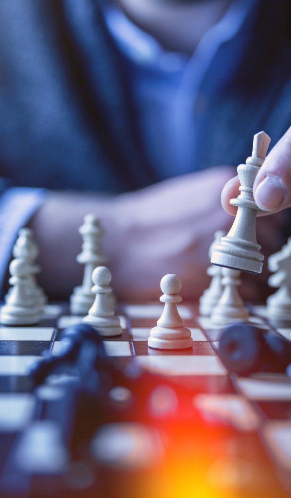 Мужчина играет в шахматы за столом