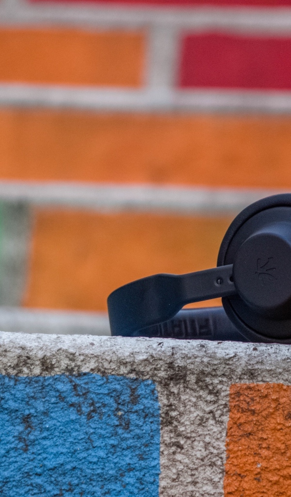 Черные наушники лежат на стене