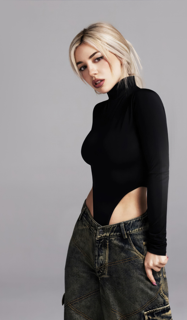 Милая блондинка певица  Эйва Макс на сером фоне