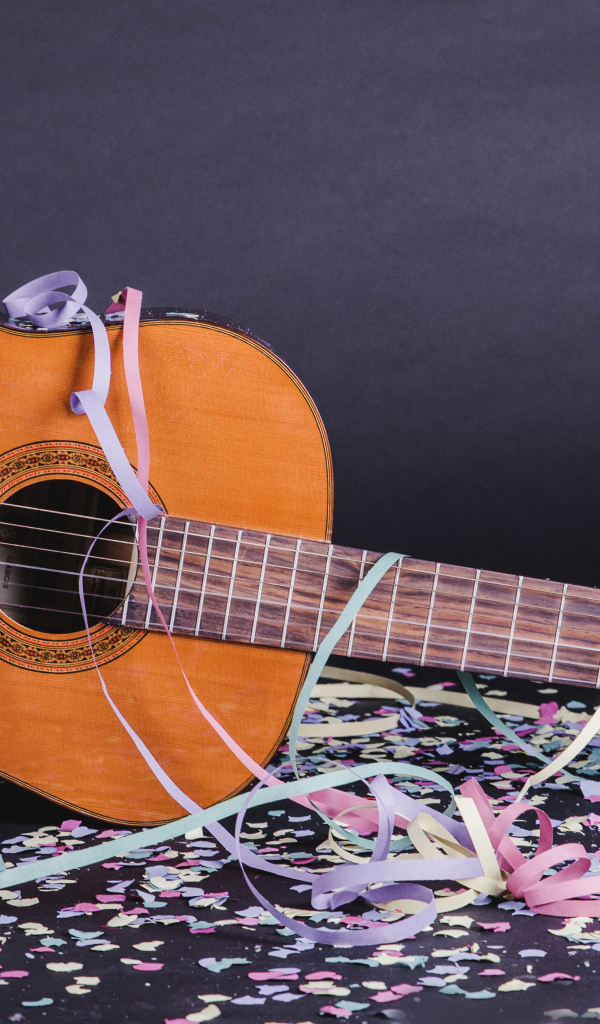 Гитара в конфетти у серой стены