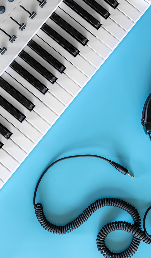 Наушники на голубом фоне с синтезатором