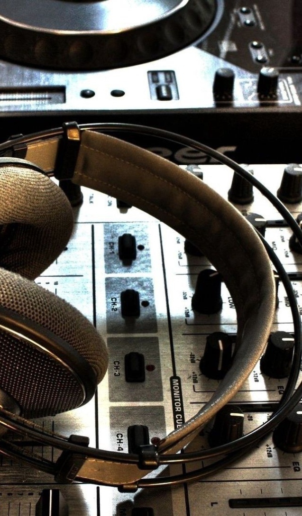 Большие наушники и микшерный пульт в студии