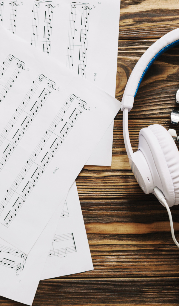 Ноты, наушники и гитара на столе