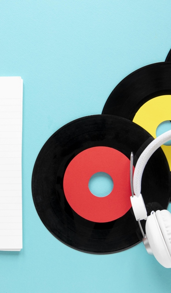 Пластинки на голубом фоне с блокнотом и наушниками