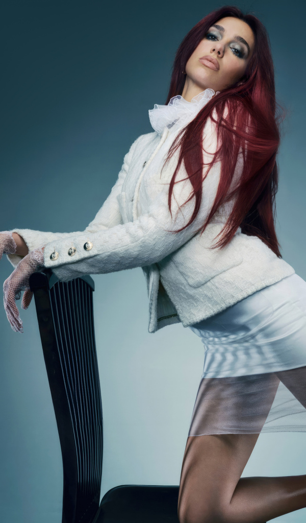 Рыжеволосая певица Дуа Липа в белом костюме у стула